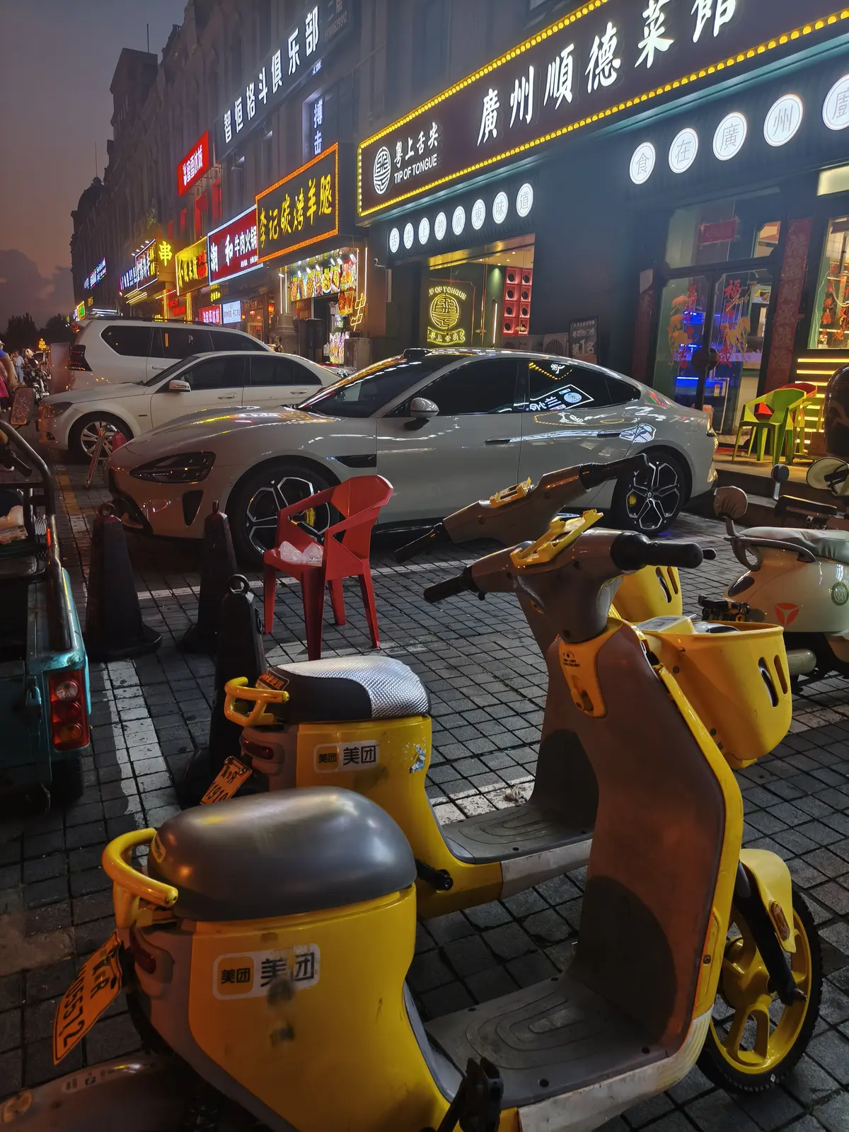 Rental scooter parked next to a Xiaomi car near Beijing