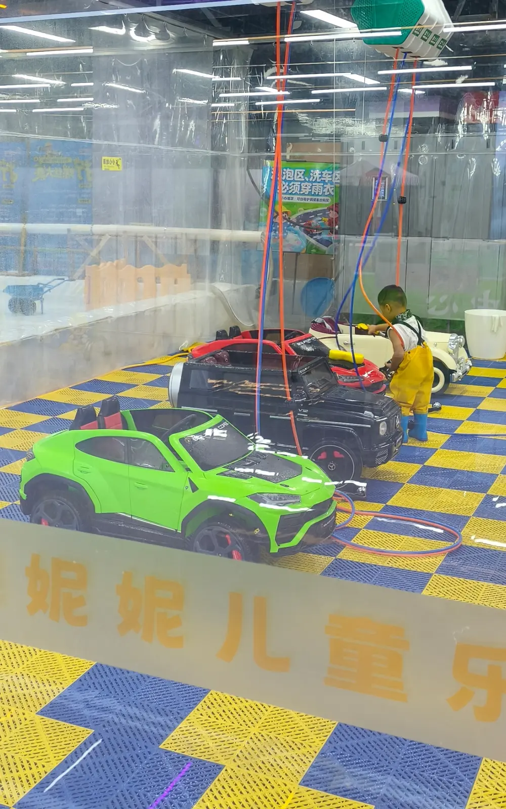Child washing a toy car with a real water jet in a Chinese mall