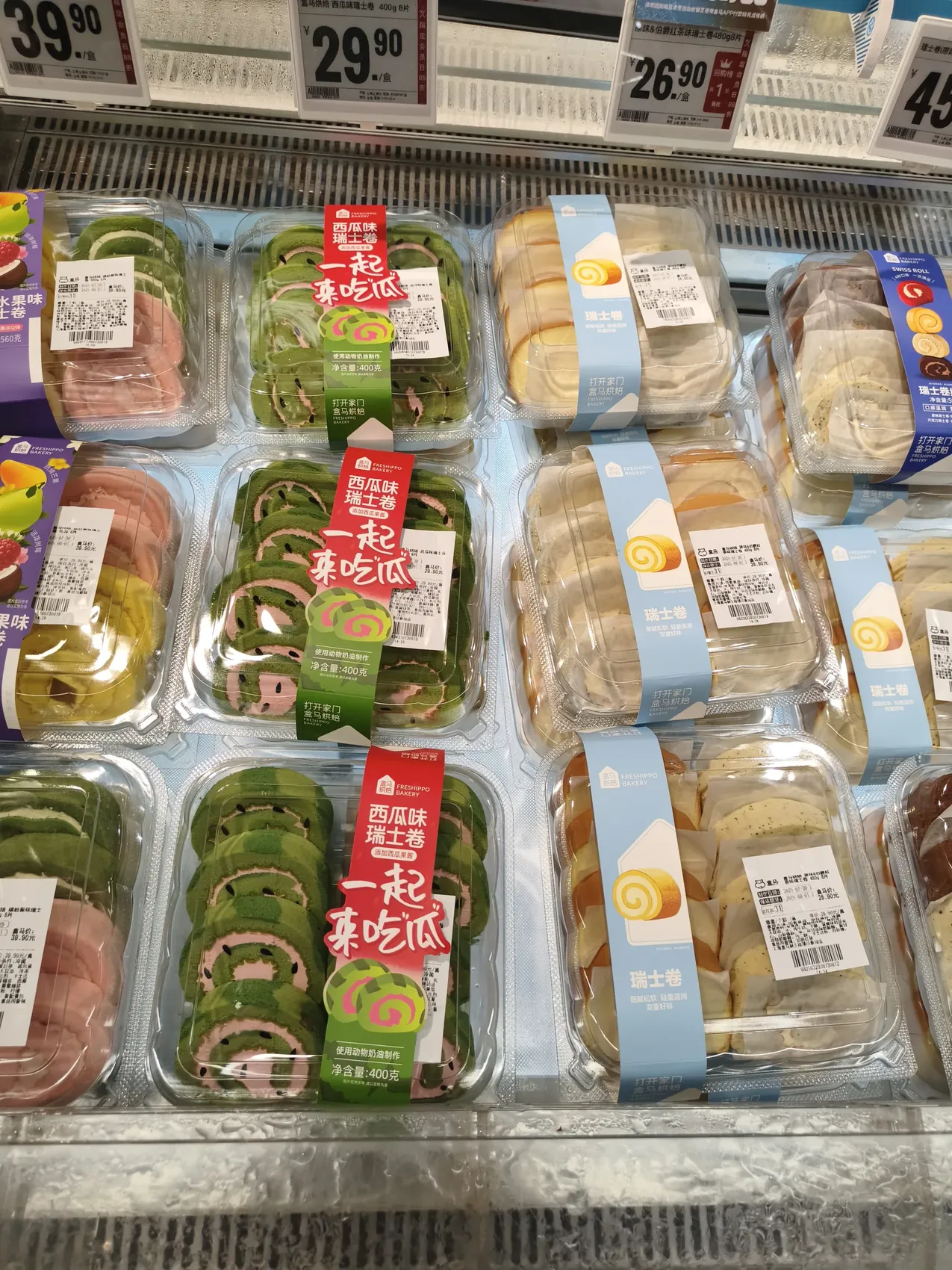 Chilled supermarket shelf of packaged Swiss rolls including a watermelon-flavored variety