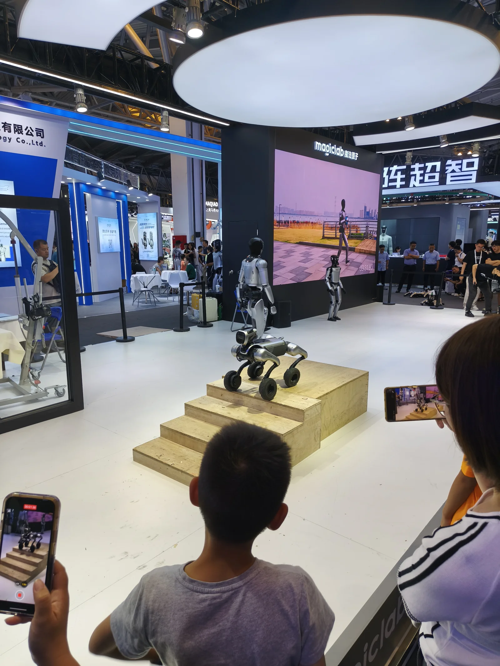 Robot dog demonstration at WAIC 2025 with audience filming on phones
